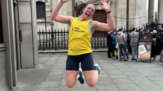 Person jumping in the air wearing a running vest